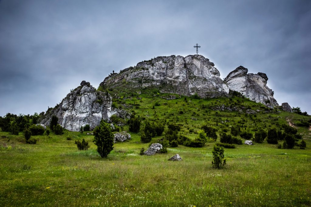Widok na skalne wzgórze na Jurze - skałki Góry Biakło z krzyżem na środku