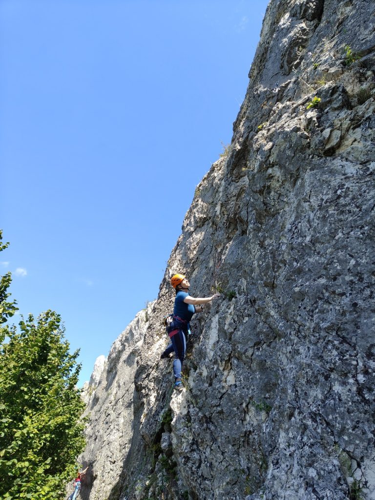 Kobieta wspina się na Powroźnikowej skale w Dolinie Racławki.